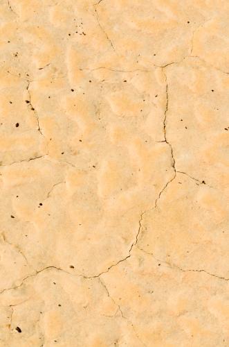 Detail shots of yellow patterned desert claypans with cracks - Australian Stock Image