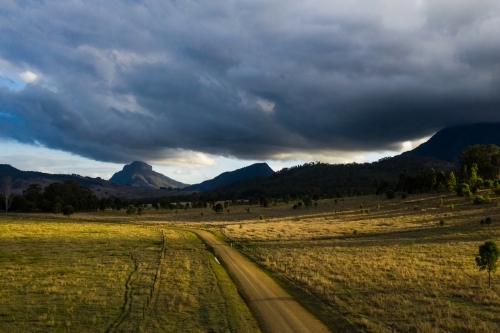 dirt road in front of mountains - Australian Stock Image