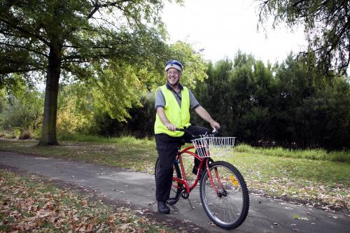 Disabled man in high visibilty vest with bike - Australian Stock Image