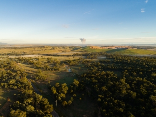 Distant open cut mine on the horizon and power station water vapor - Australian Stock Image