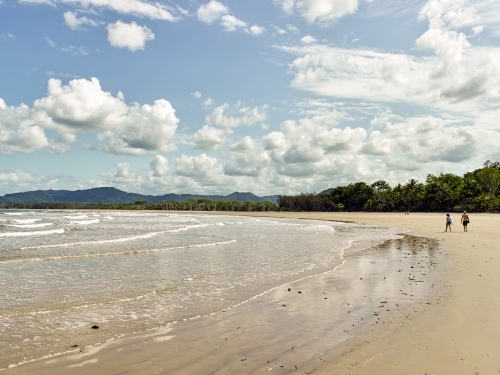 Distant people walking on a tropical beach - Australian Stock Image