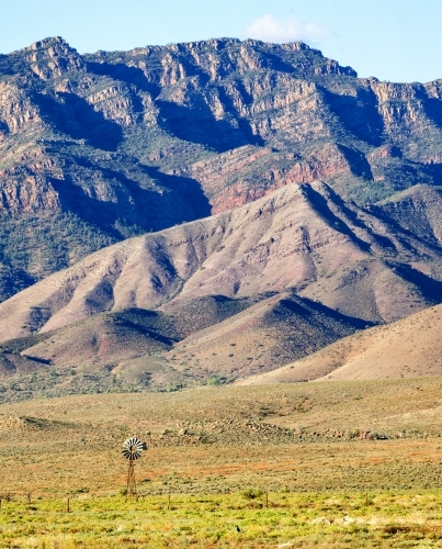 Distant windmill in front of rugged ranges, portrait - Australian Stock Image