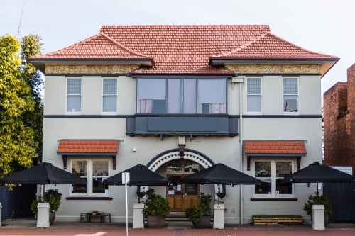 Double storey building with umbrellas and arch doorway - Australian Stock Image