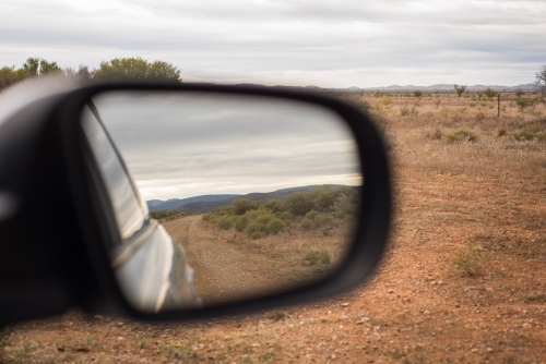 Driving, looking at reflection in side window of remote country - Australian Stock Image