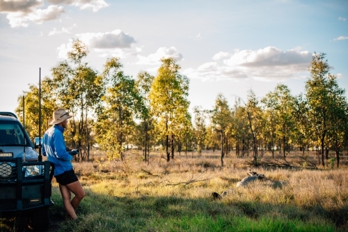 Drone Pilot with remote control in a tree paddock - Australian Stock Image