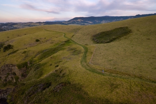 Drone Shot of Man Running on Hillside - Australian Stock Image