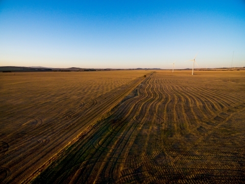 Drone shot of wind turbines in stubble paddock in late afternoon - Australian Stock Image