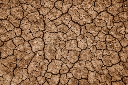 Dry brown cracked soil texture from above - Australian Stock Image