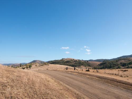 Dry summer countryside with brown grass and clear blue sky - Australian Stock Image