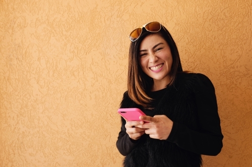 Southeast Asian multicultural woman using mobile phone - Australian Stock Image