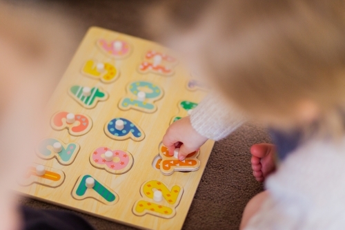 Education, young girls learning about numbers with a puzzle - Australian Stock Image