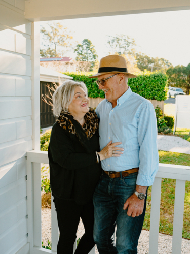 Elderly couple looking at each other lovingly on the porch - Australian Stock Image