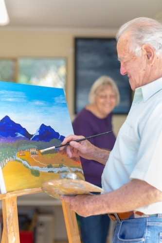 Elderly couple painting in art studio