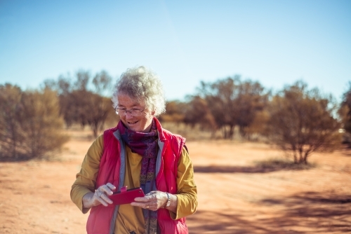 Elderly woman with phone in the Northern Territory - Australian Stock Image