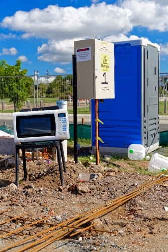 Electrical appliances exposed to the elements, on a chair at a new construction site - Australian Stock Image