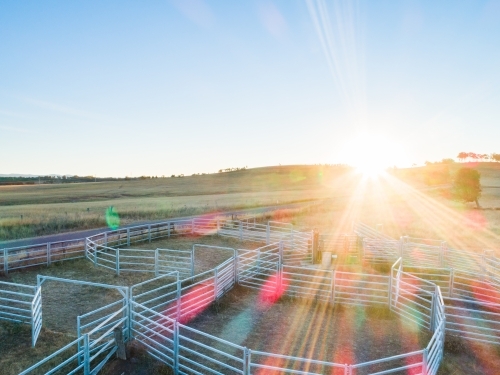 Evening sunlight shining over cattle ramp and stock yards on farm - Australian Stock Image