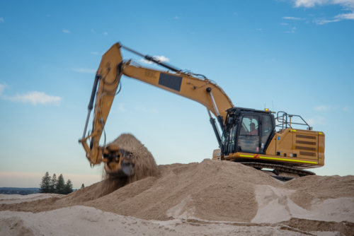 Excavator at work digging sand at Dolls Point - Australian Stock Image