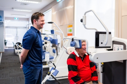 exercise therapy equipment at physiotherapy clinic with happy man and physio - Australian Stock Image