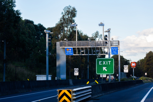 Exit sign beside tollway with end toll point road signs - Australian Stock Image