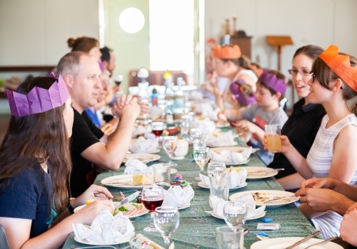 Extended family eating food together celebrating Christmas day lunch - Australian Stock Image