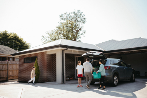 Family loading things into the boot of the car. - Australian Stock Image