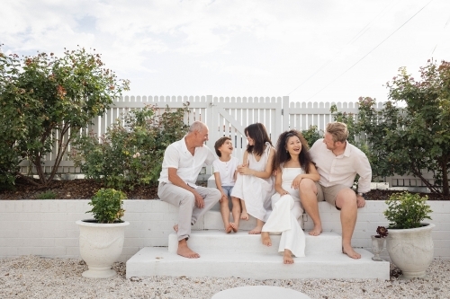 Family of five sitting on backyard steps - Australian Stock Image