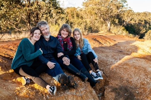 Family of four with teen and adult daughters siting together - Australian Stock Image