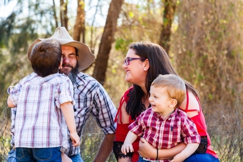 Family of four with two boys smiling together - Australian Stock Image