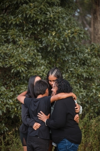 Family or friends sharing a group hug - Australian Stock Image