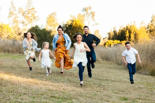 Family running together through park