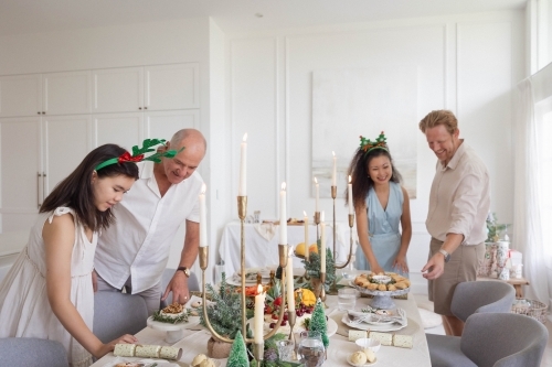 Family setting up Christmas table together - Australian Stock Image