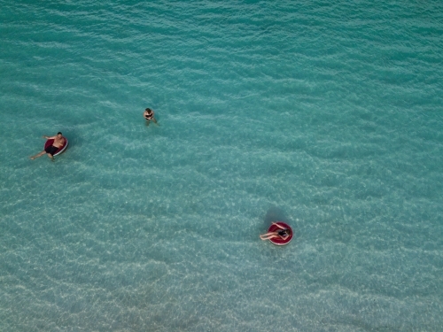 family swimming in clear blue water - Australian Stock Image