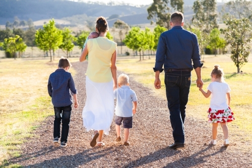 Family walking down driveway of farm - Australian Stock Image