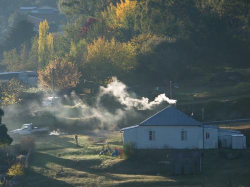 Farm house with smoke coming from chimney - Australian Stock Image
