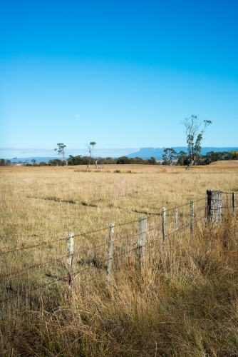 Farm paddock fence with mountains in background - Australian Stock Image