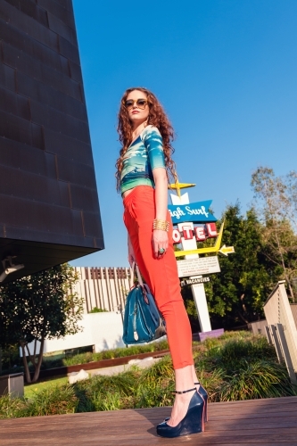 fashion conscious tall young woman looking down on the ground - Australian Stock Image
