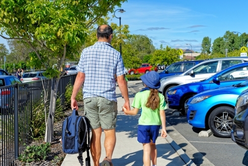 Father and daughter walking hand in hand to school - Australian Stock Image