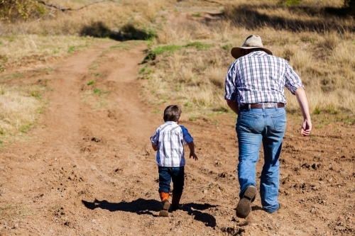 Father and son race up dirt 4WD track - Australian Stock Image