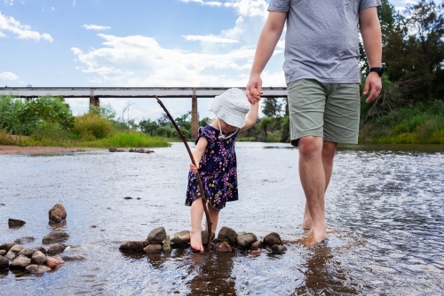 Father and toddler girl wading in Hunter River at Rose Point in Singleton - Australian Stock Image