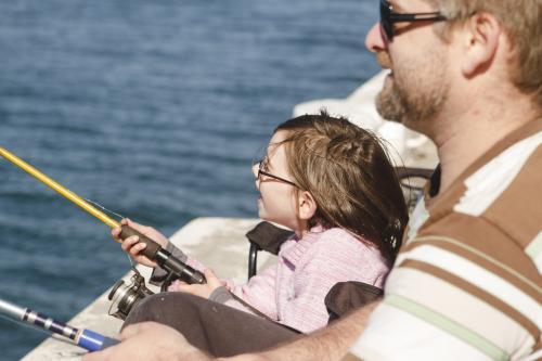 Father and young daughter fishing off wharf - Australian Stock Image