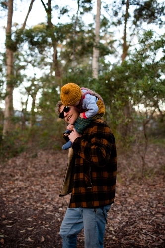 Father carrying toddler on shoulders in the bush - Australian Stock Image