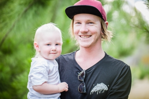 Father holding child looking and smiling - Australian Stock Image