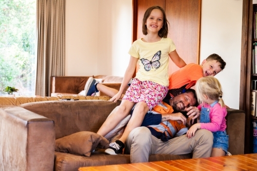 Father home from work playing with his children - Australian Stock Image