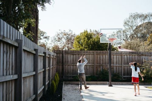 father playing basketball in the backyard with a pre-teen girl - Australian Stock Image