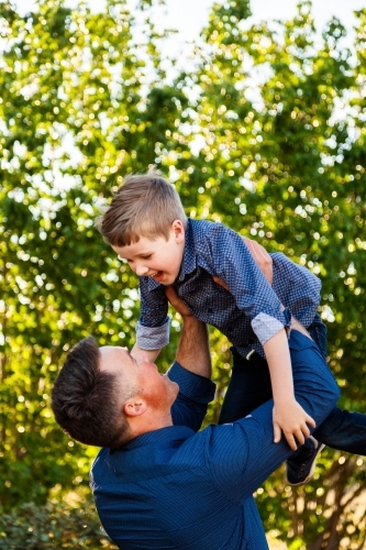 father throwing son in the air laughing - Australian Stock Image