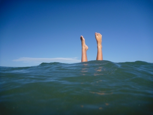 Feet in the air in ocean water - Australian Stock Image