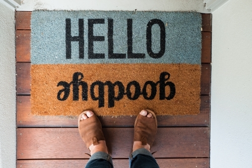 Feet on a front door mat. - Australian Stock Image