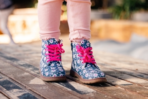 Feet only shot of little girl's bright boots with pink laces - Australian Stock Image