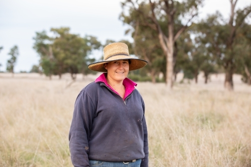 Female farmer in a paddock on her farm - Australian Stock Image