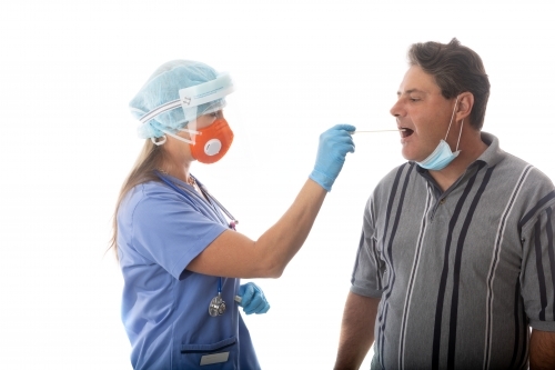 Female healthcare worker swabs a man for infectious disease such as SARS or COVID-19 or influenza